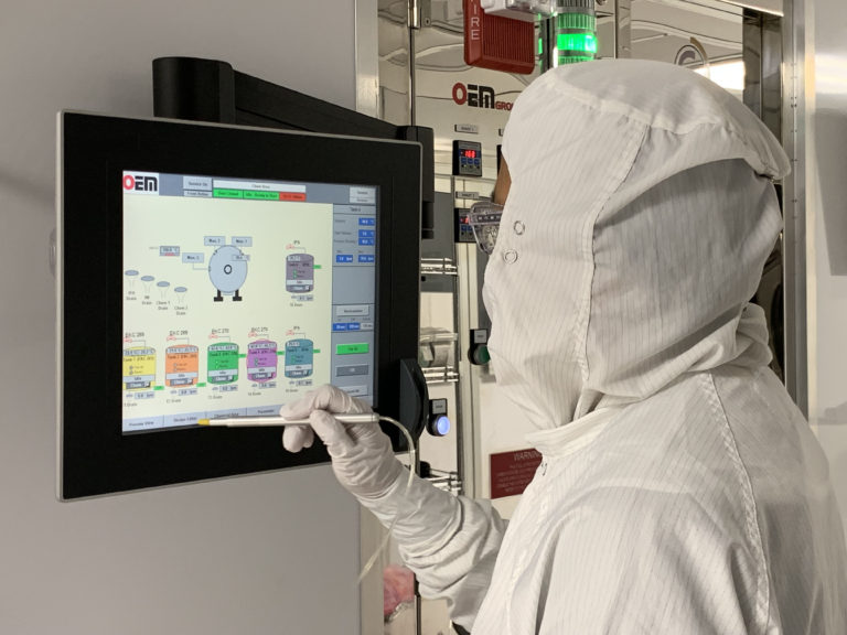 Cleanroom technician operating wafer fabrication equipment